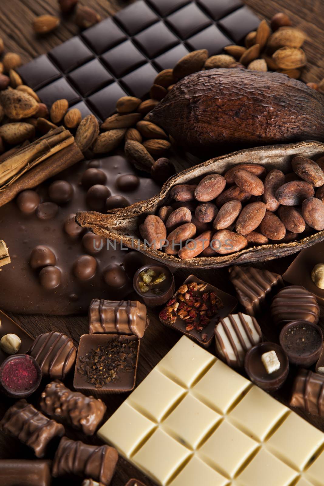 Chocolate bars and pralines on wooden background