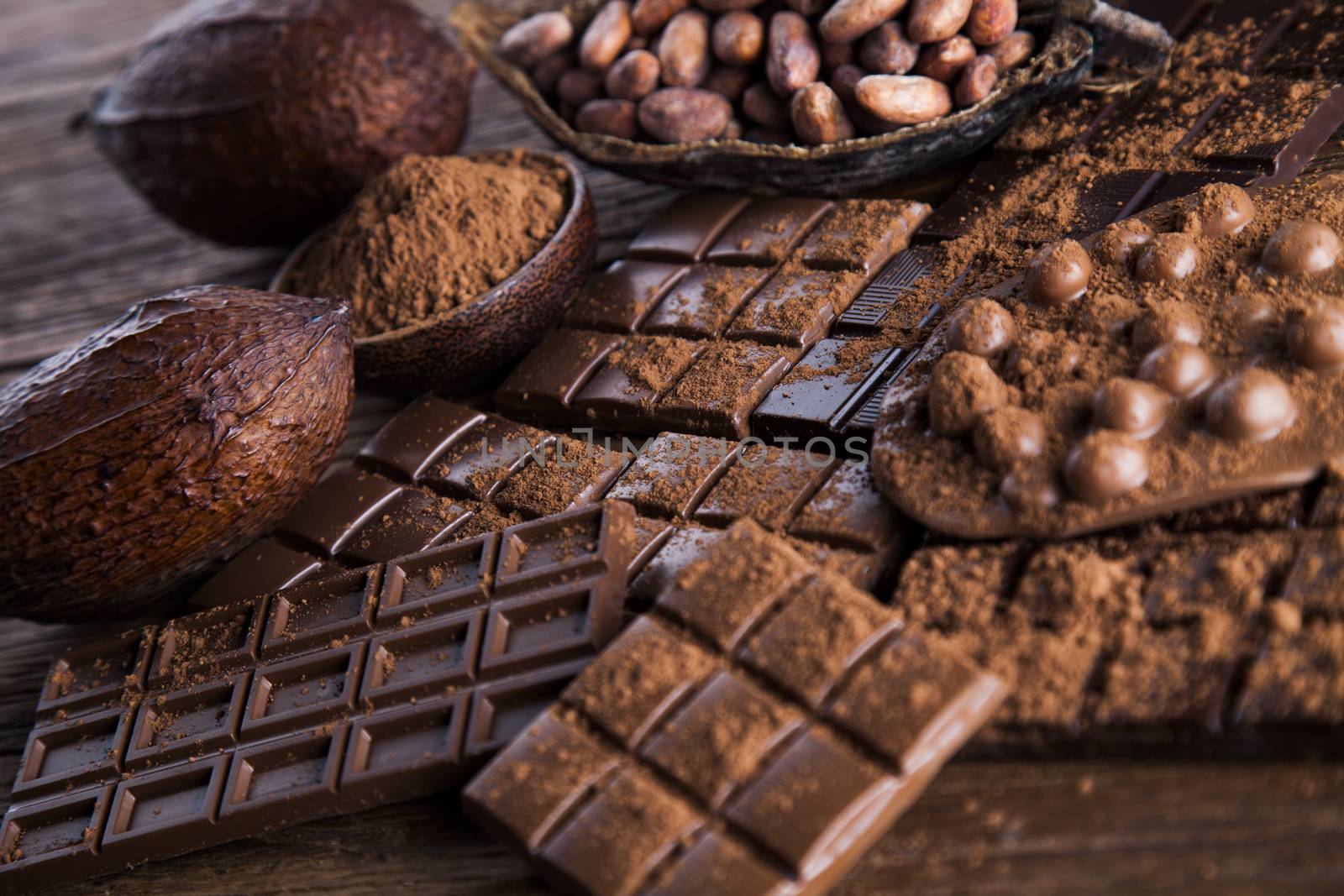 Dark homemade chocolate bars and cocoa pod on wooden  by JanPietruszka