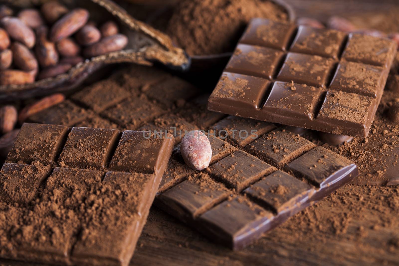 Dark and milk chocolate bar on a wooden table  by JanPietruszka