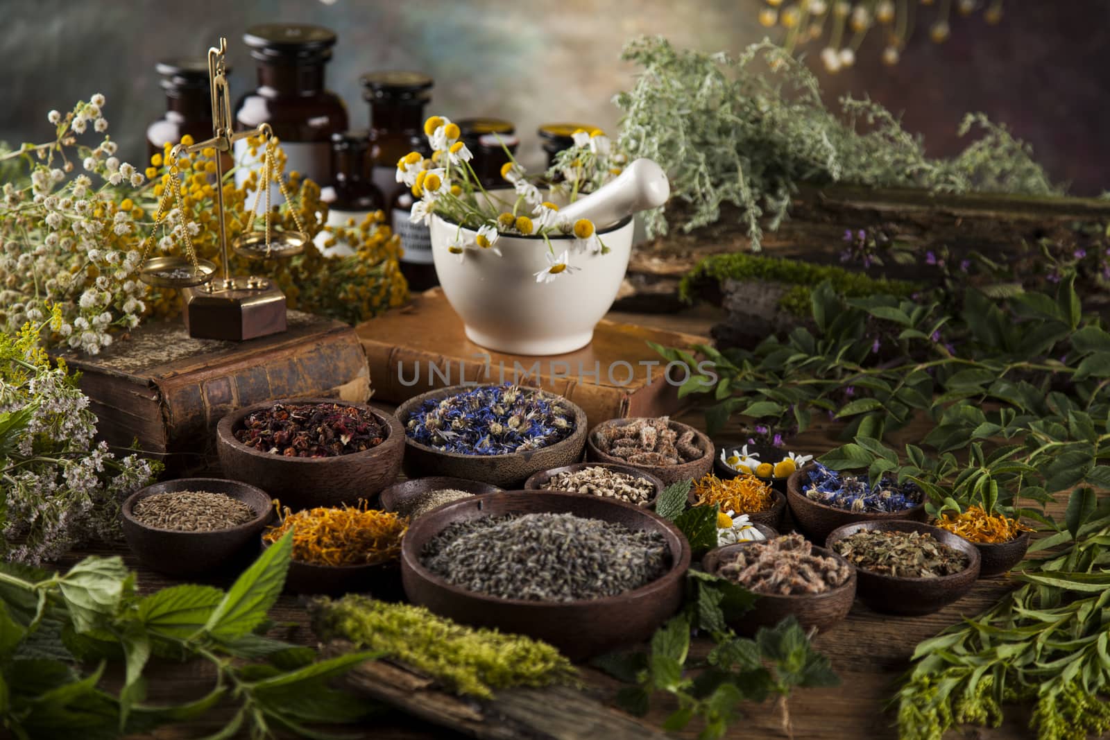 Herbs, berries and flowers with mortar, on wooden table background