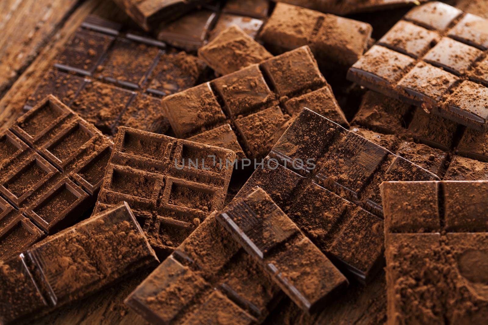 Dark homemade chocolate bars and cocoa pod on wooden