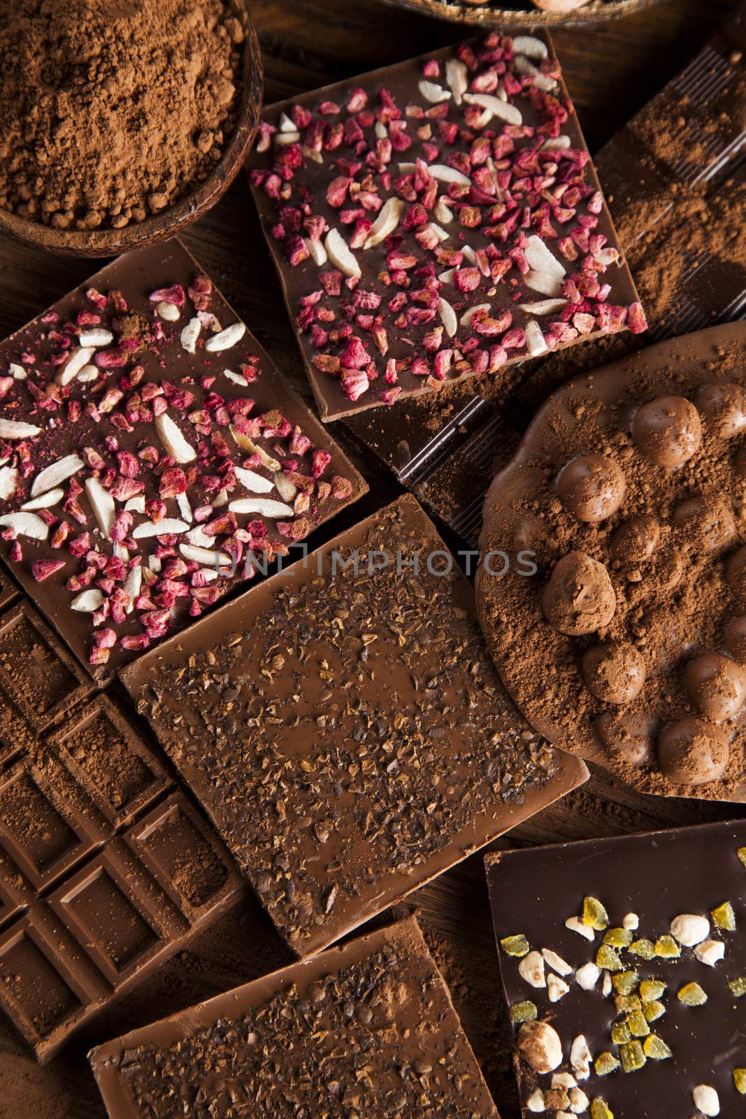 Dark homemade chocolate bars and cocoa pod on wooden