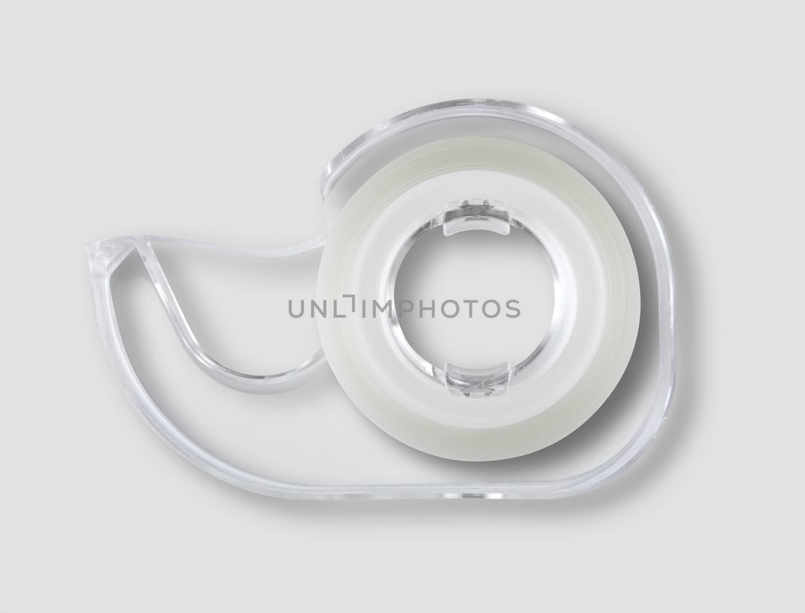 Transparent scotch tape dispenser isolated on grey background