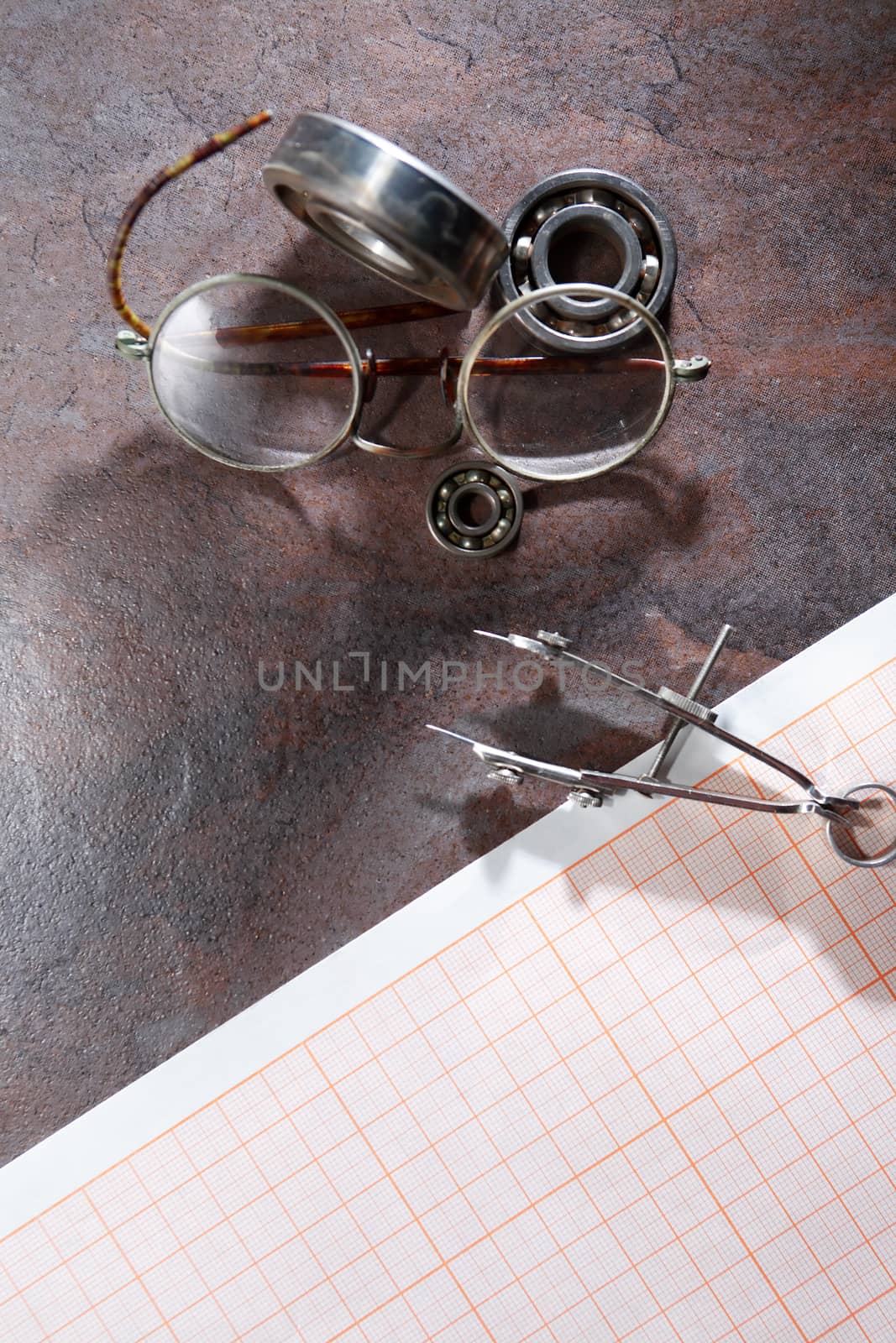 Engineering concept. Set of  ball bearings on grapah paper near spectacles