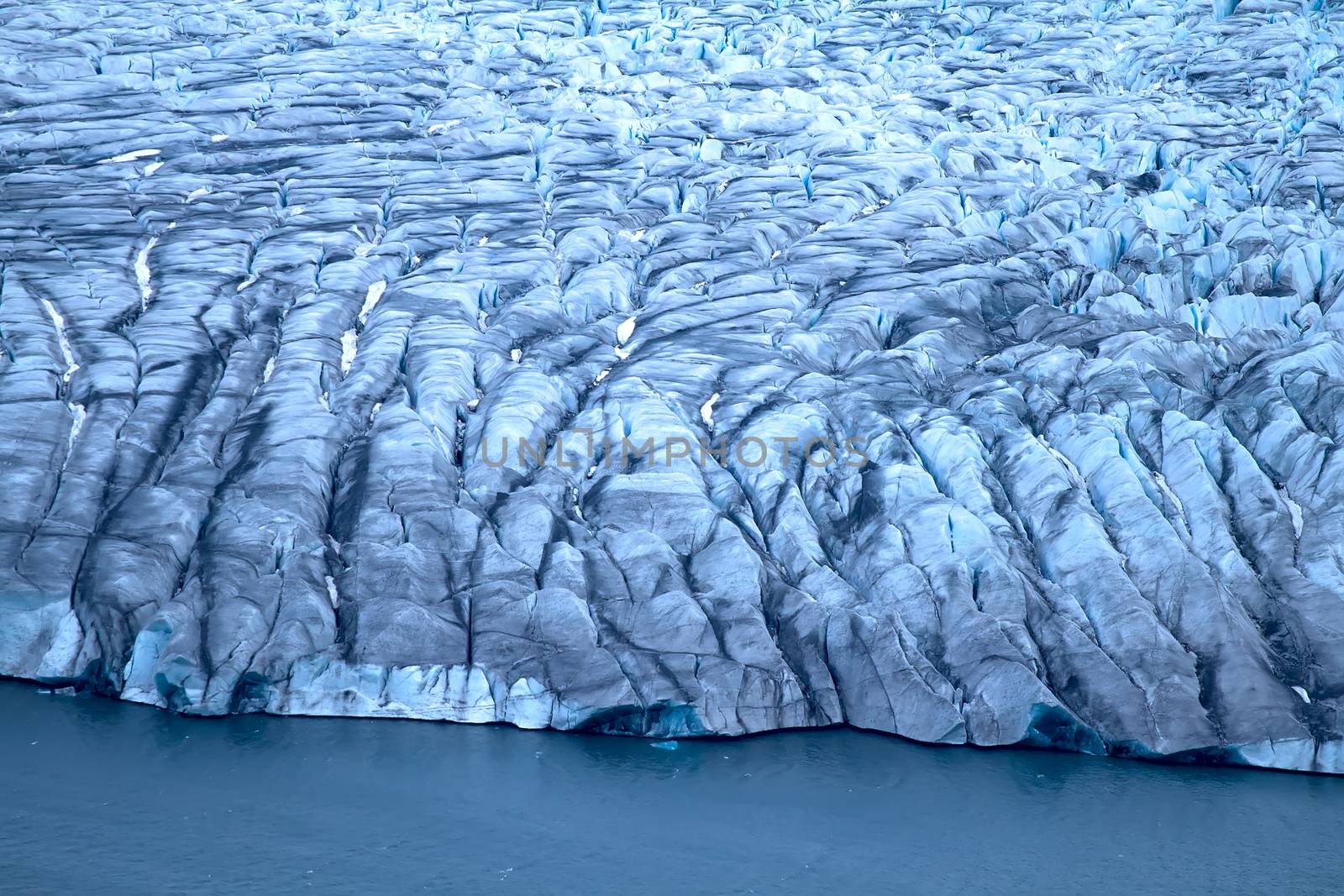 Harsh glaciers of Arctic. Live glacier: front wall and icefall (recently calved ice block in ablation zone). Novaya Zemlya archipelago, North island. View from helicopter