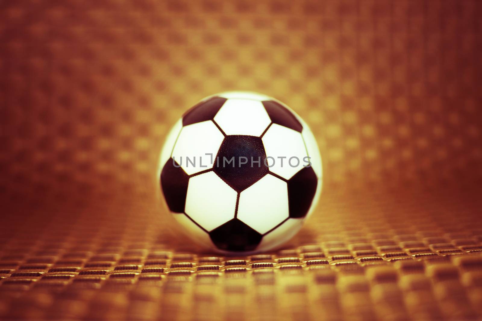 A toy soccer ball on an artificial background. Concept of the game of football