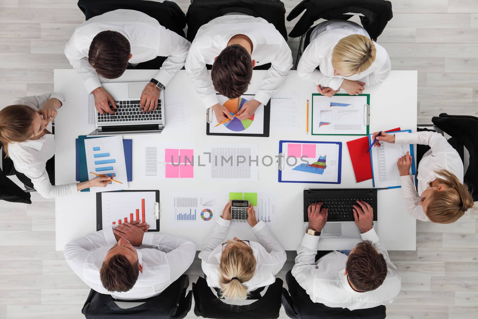 Business people work with statistics documents with tables and diagrams sitting around the table