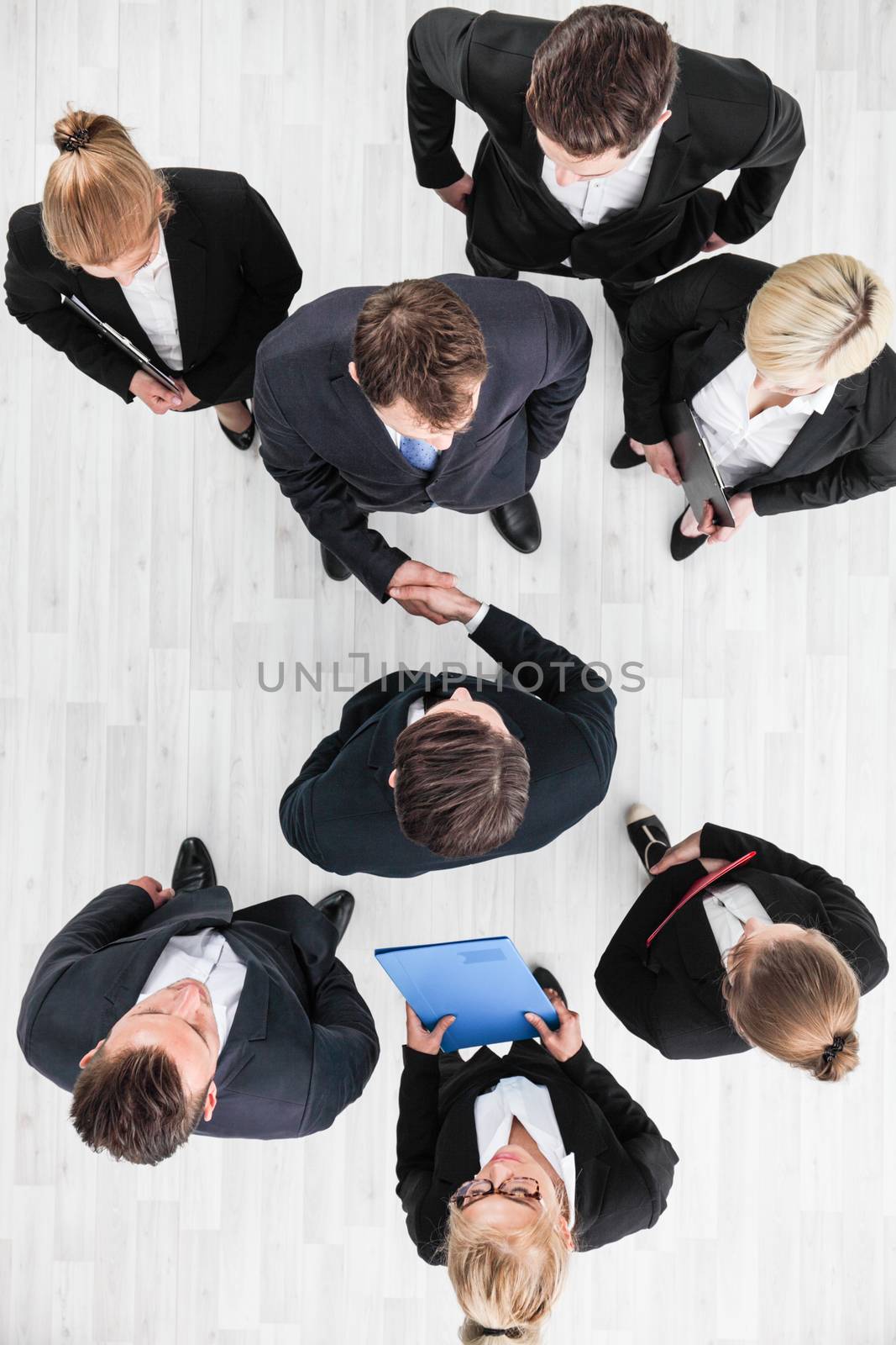 Business people shaking hands, finishing up a meeting, top view