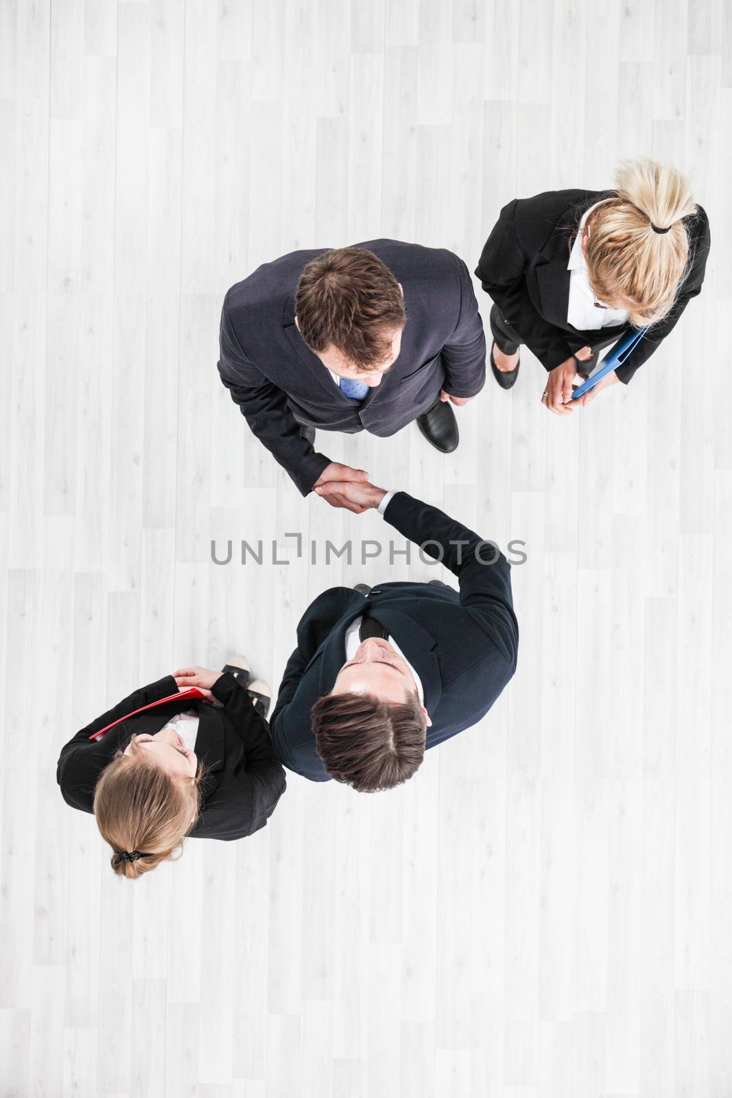 Business people shaking hands, finishing up a meeting, top view with copy space