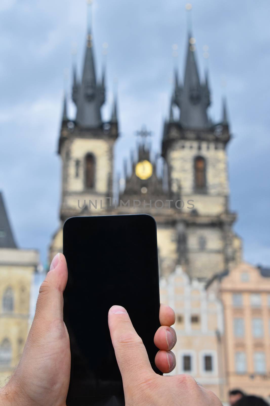 Man hand taking picture of Prague with phone by BreakingTheWalls