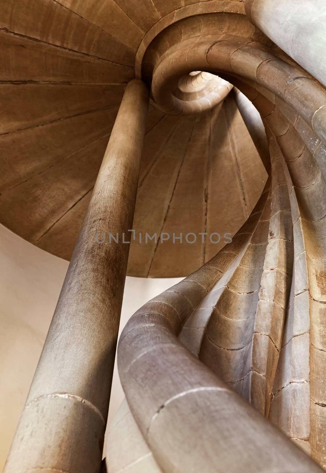 Spiral stone stair in old medieval tower, diminishing perspective, low angle view