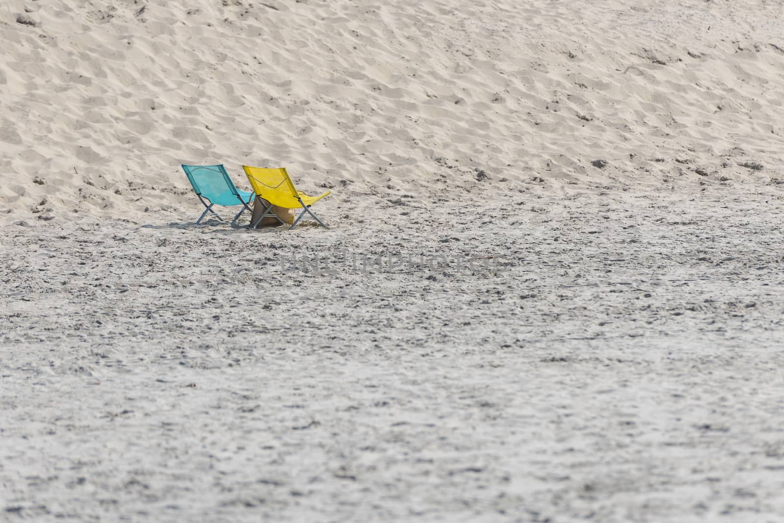 A blue and yellow folding chair on a beach
 by Tofotografie