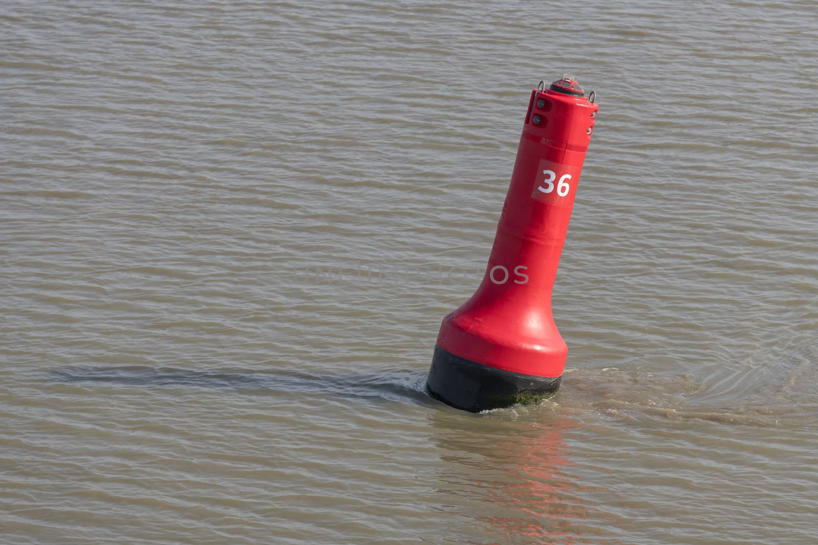 Red buoy as a marker for shipping on the UNESCO protected Wadden Sea in the North of the Netherlands
