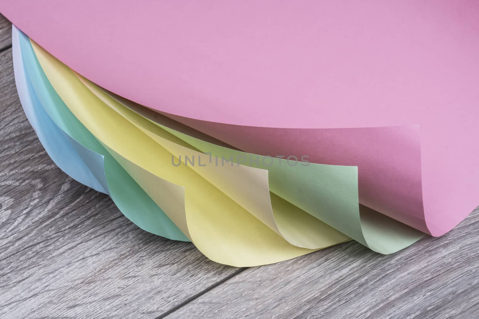 sheets of colored paper on a wooden table