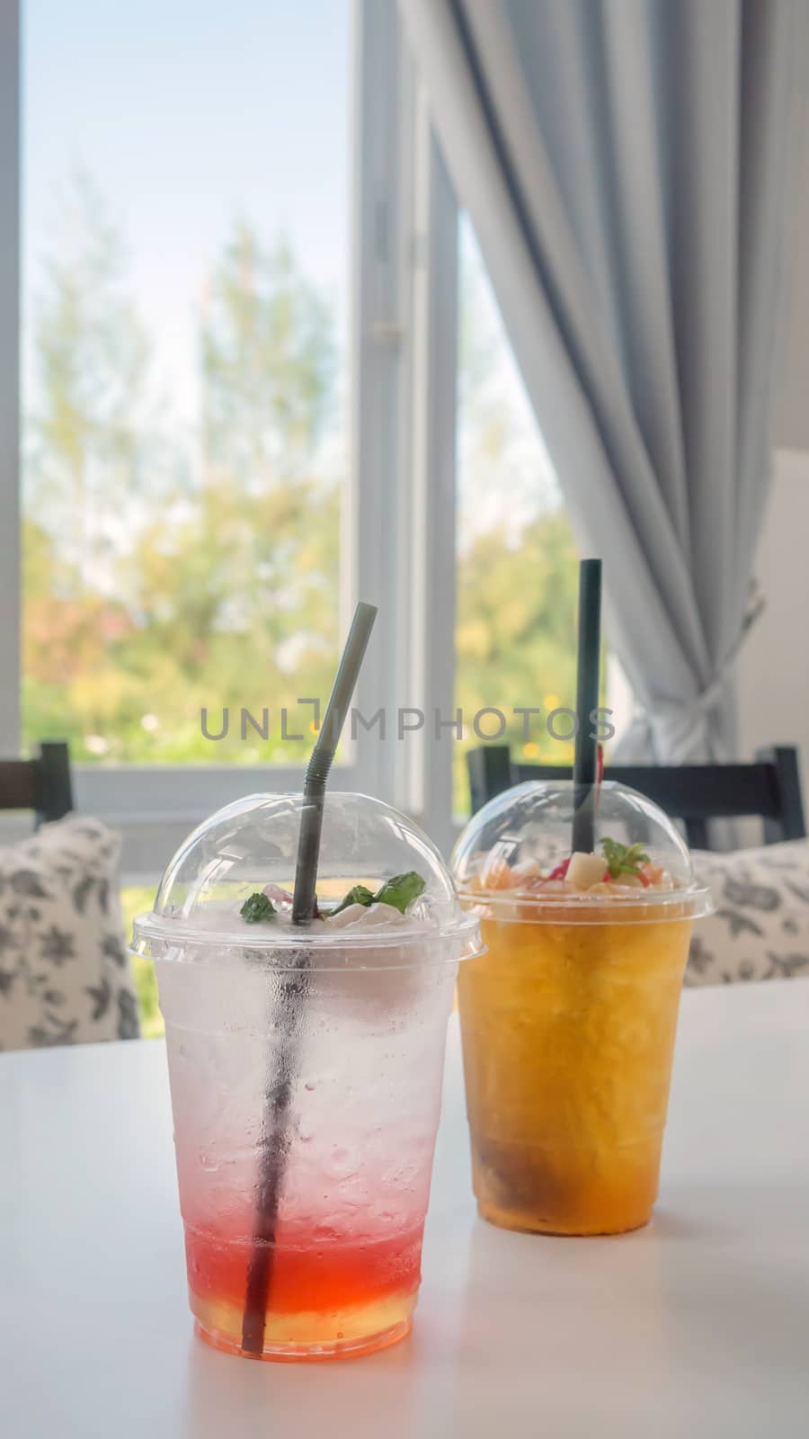 cocktail with fresh sliced fruits arranged in plastic cups