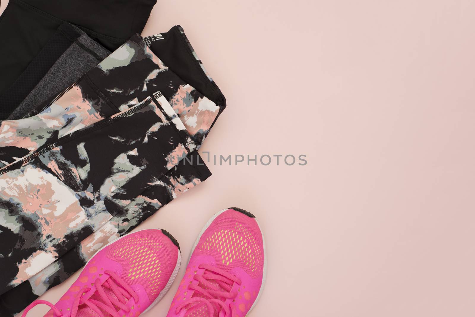 Female pink sneakers, sport shoes, leggings in flat lay style, top view. Fitness concept, active lifestyle, body care concept. Copy space