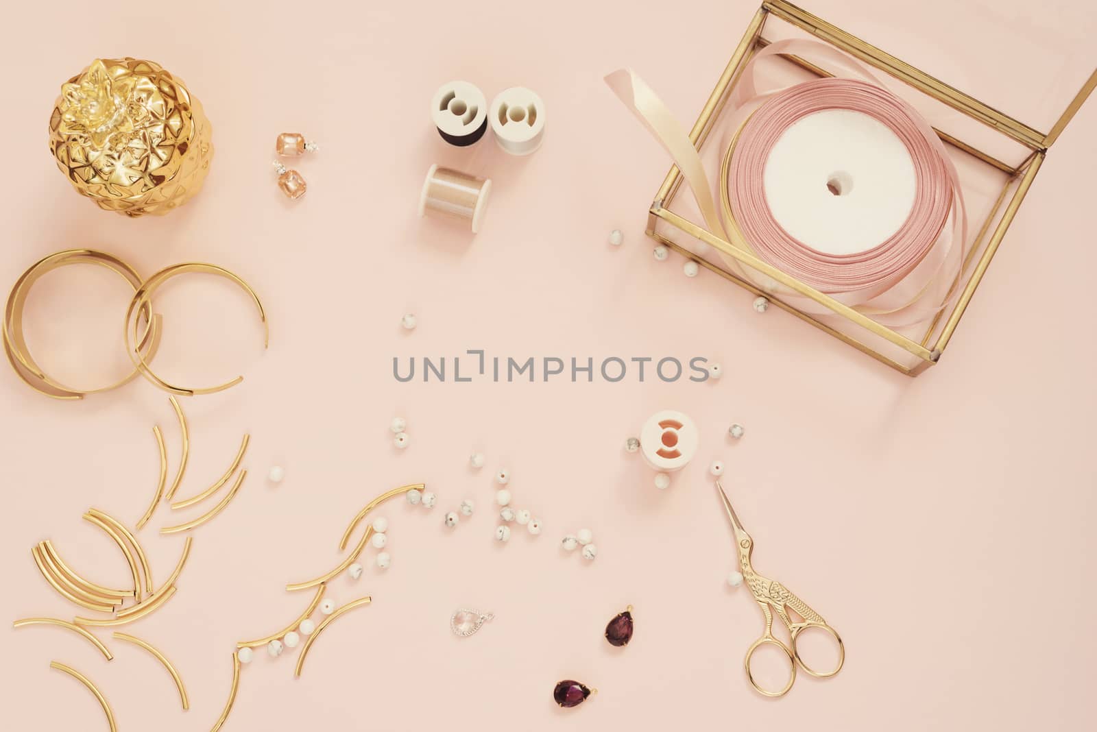 Jewelry designer workplace. Handmade, craft concept. Materials for making jewelry ? golden scissors, ribbons, gold tubes, bracelet settings. Freelance workspace in flat lay style.