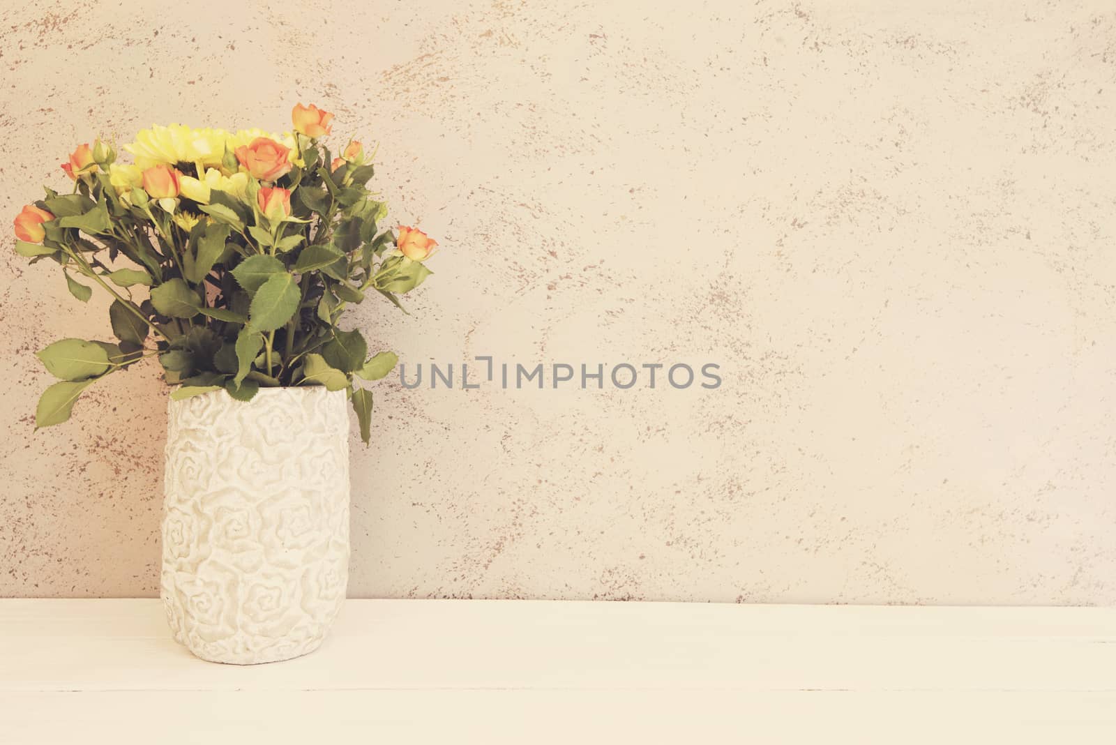 Vase of flowers. Rustic vase with orange roses and yellow chrysanthemums. White background, empty place, copy space. Vintage tinted