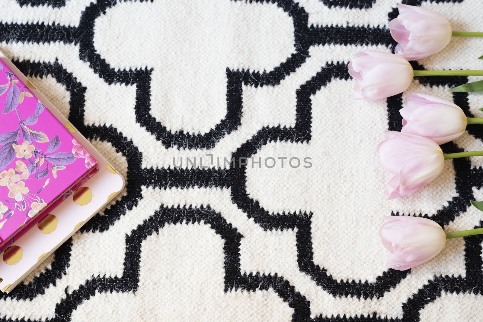 Pink Tulips frame over Scandinavian rug. White black pattern. Lifestyle concept. Copy Space. Flower Frame, Border