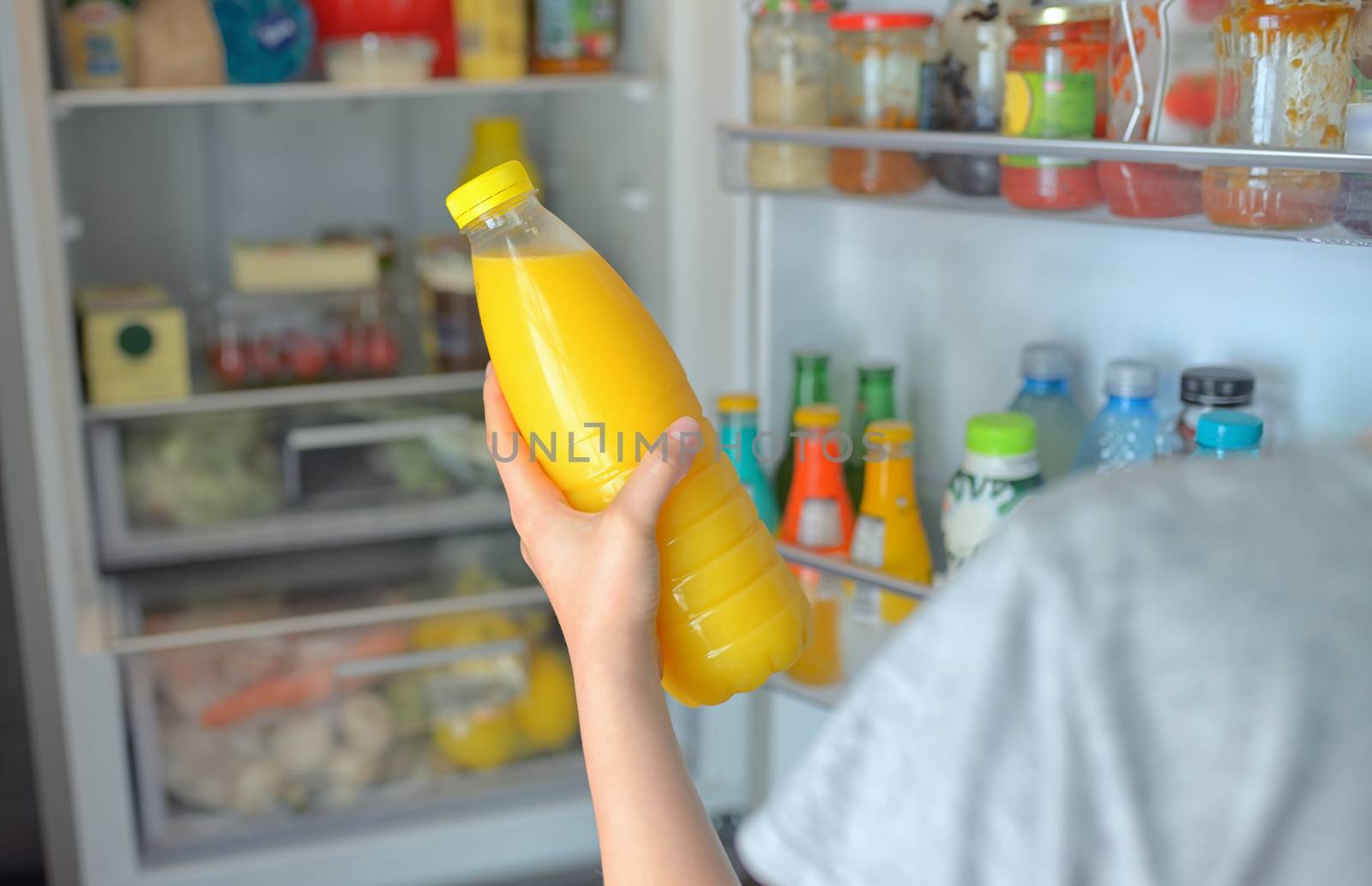 Teenage girl takes the orange juice from the refrigerator by mady70