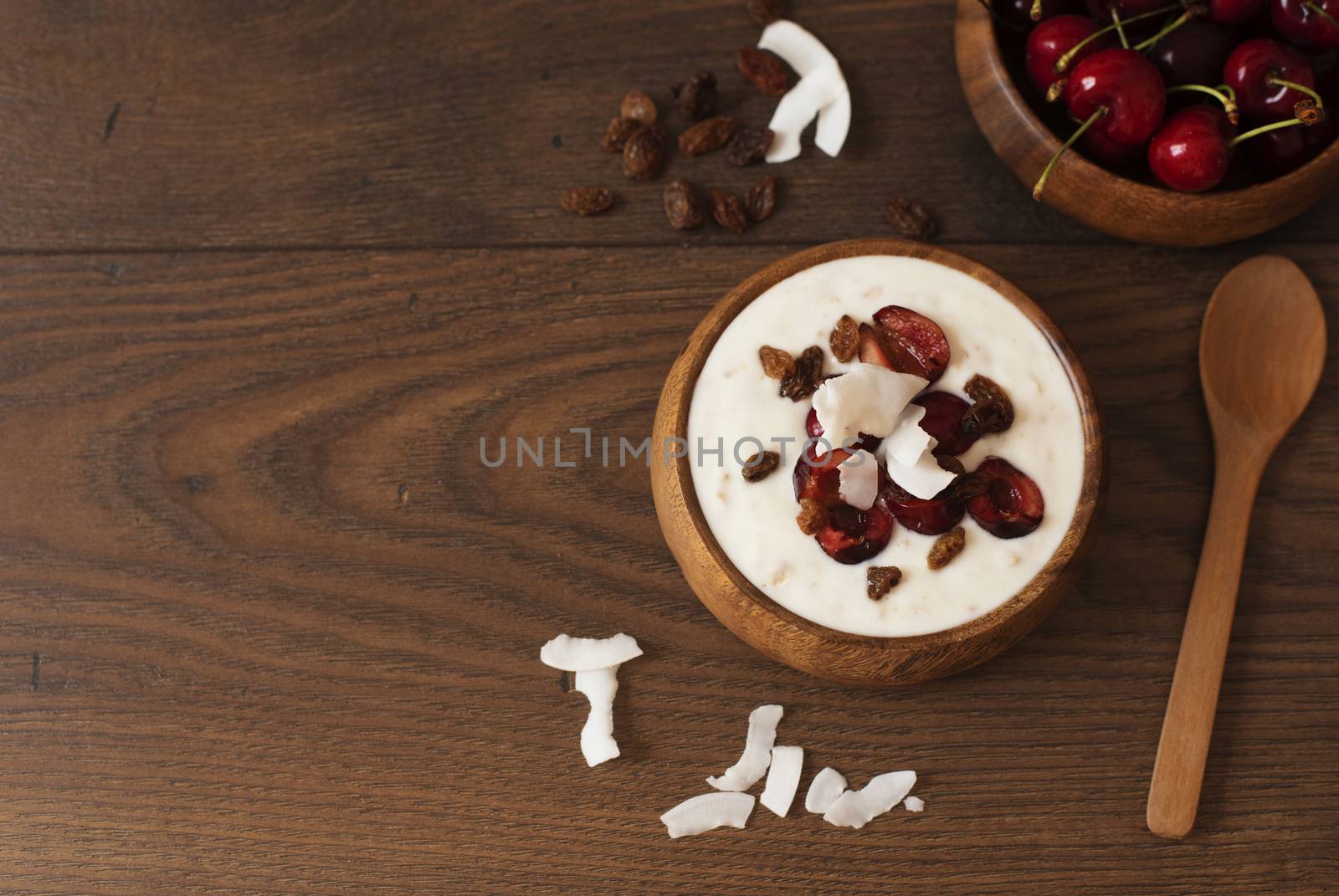 Oat Flakes With Yogurt And Fruits. Cherries, Raisins And Coconut Chips. Overnight Breakfast. Healthy Food Concept. Fitness Mood Diet. Summer Light Snack. Dark Wooden Background