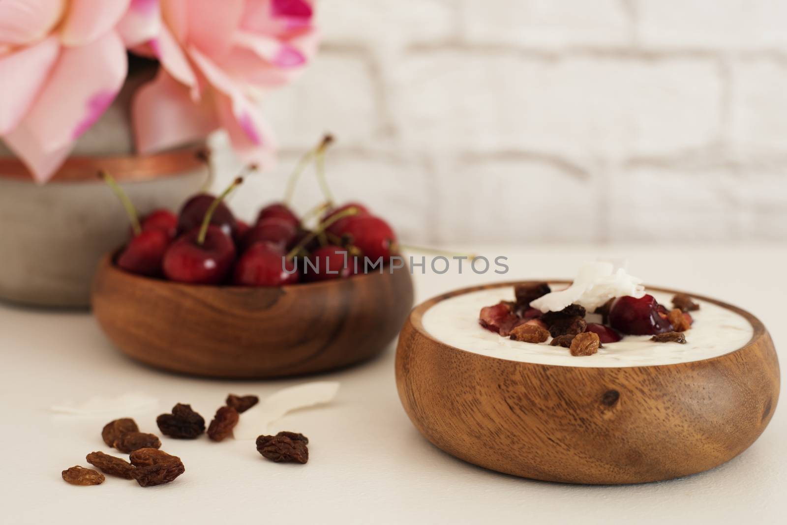 Oat Flakes With Yogurt And Fruits. Cherries, Raisins And Coconut Chips. Overnight Breakfast. Healthy Food Concept. Fitness Mood Diet. Summer Light Snack. Bright Brick Wall Background. 