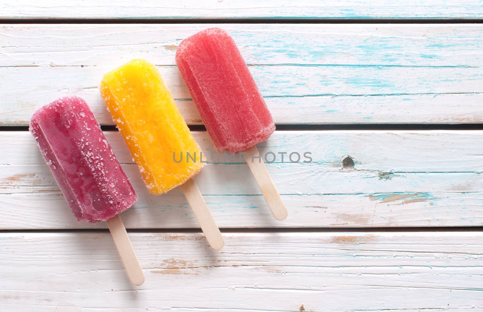 Ice lollies on white wood by unikpix