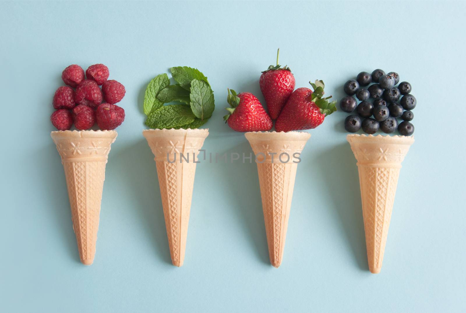 Four icecream cones with natural ingredients including berries, and mint flavors