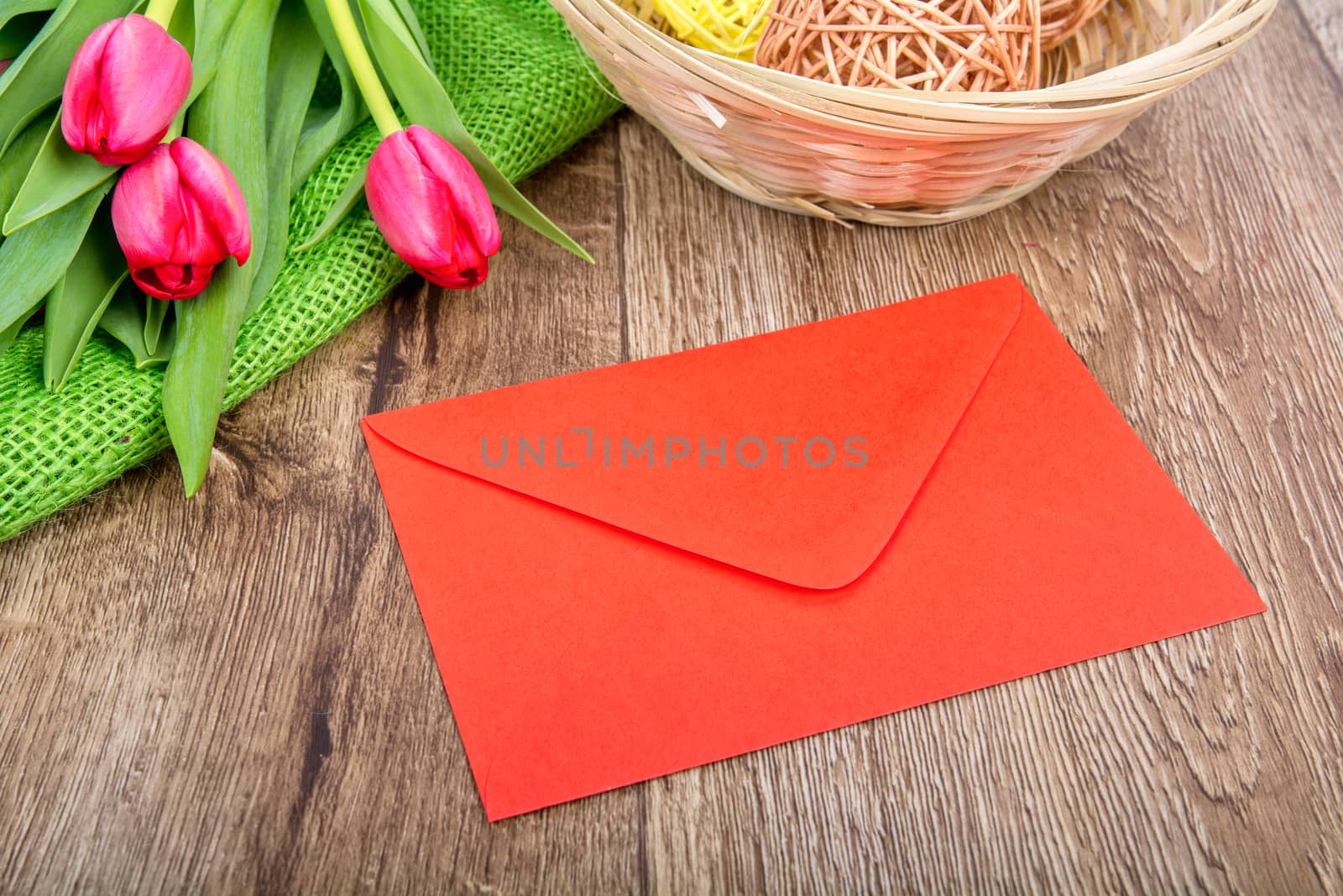 Red envelope with tulips on a wooden table by neryx