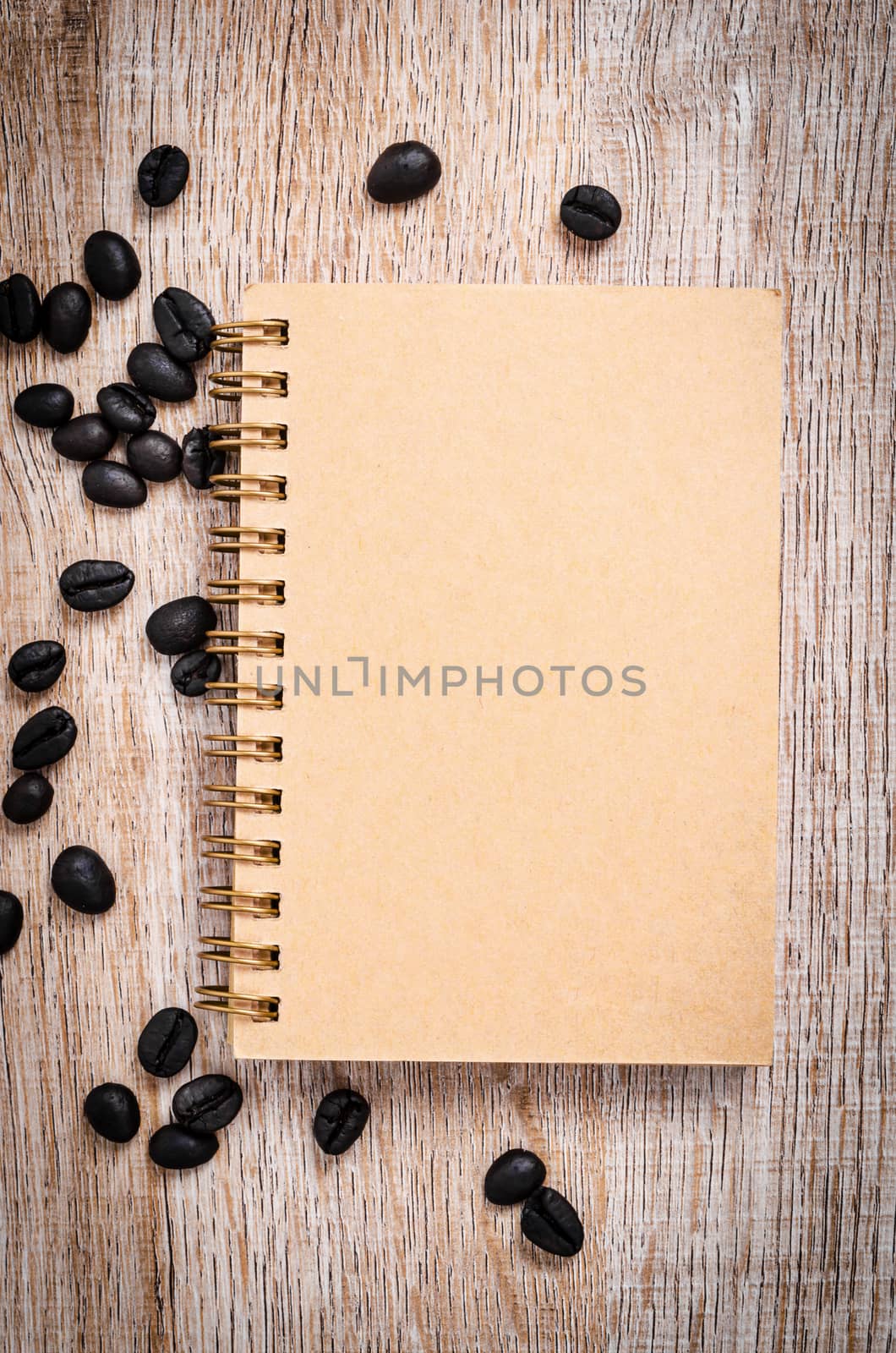 Blank vintage notebook with coffee beans. by Gamjai