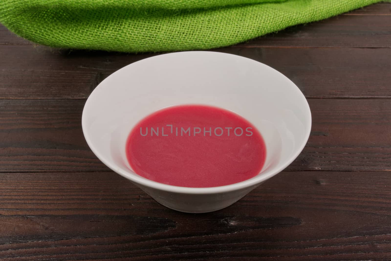 Beet soup with wine on a wooden table