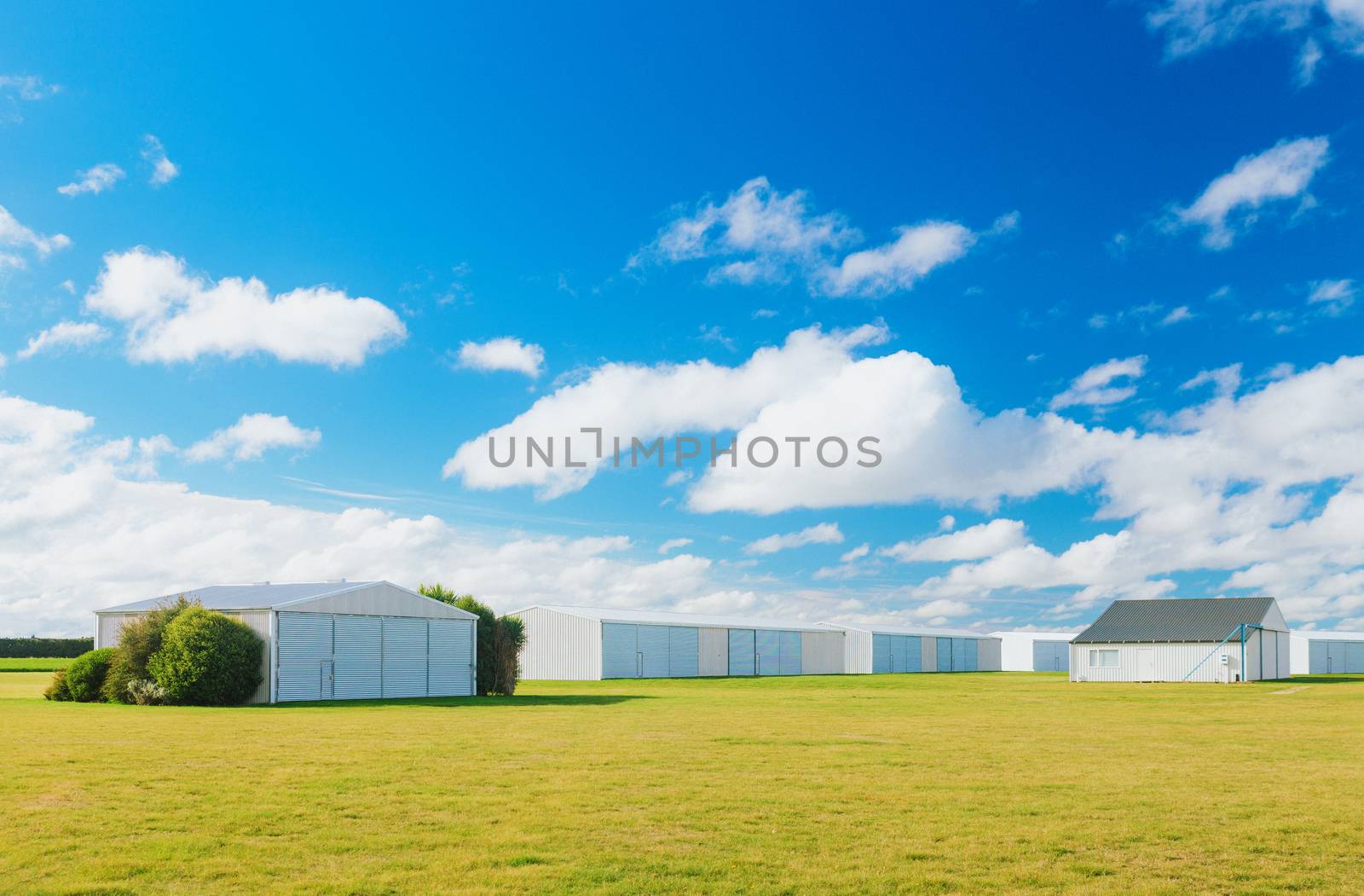 Metallic warehouse with blue sky green grass