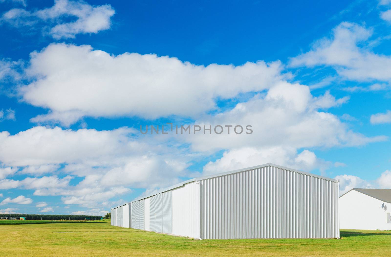 Metallic warehouse with blue sky by cozyta