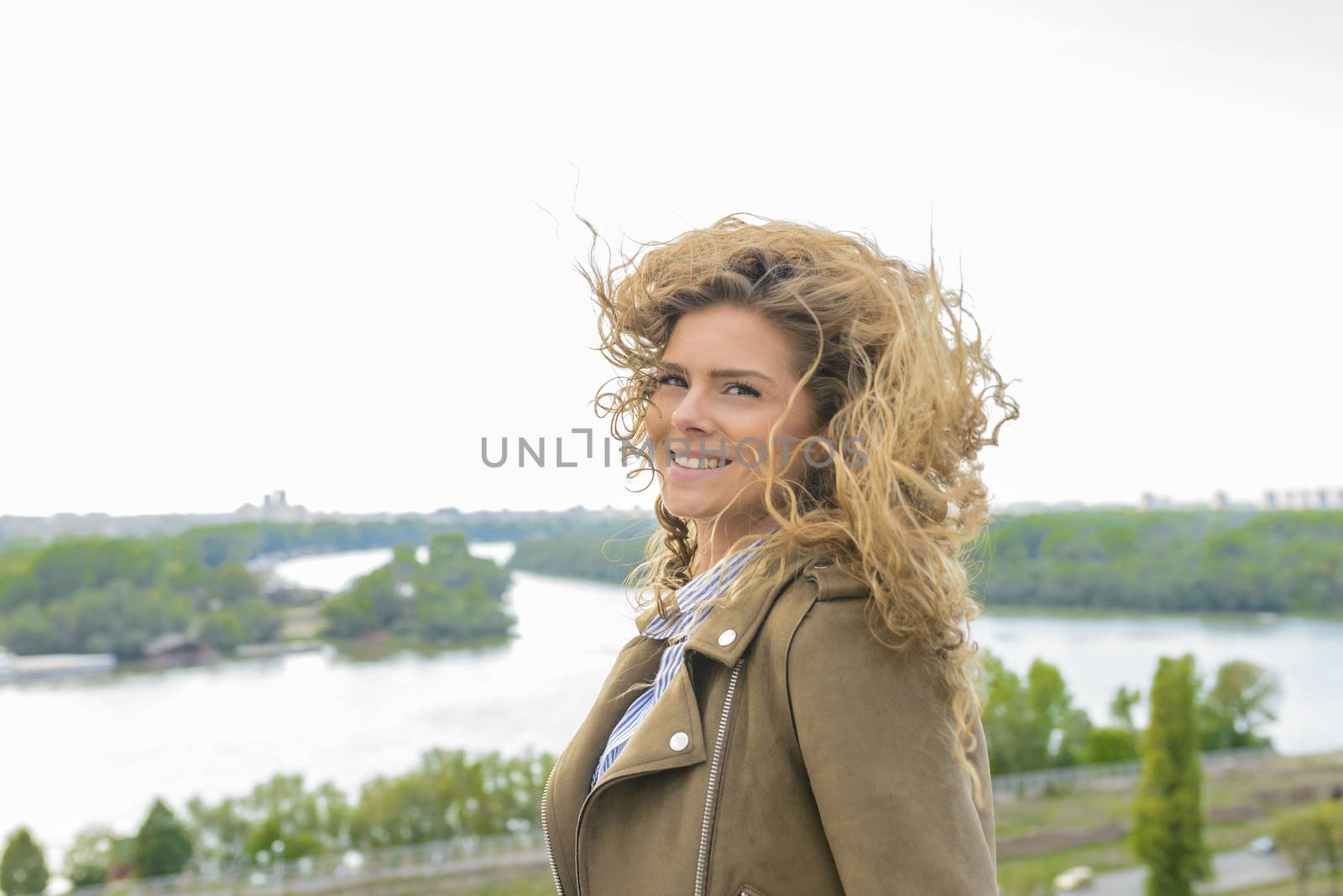 Beautiful long haired woman enjoying the landscape view on a windy cloudy day