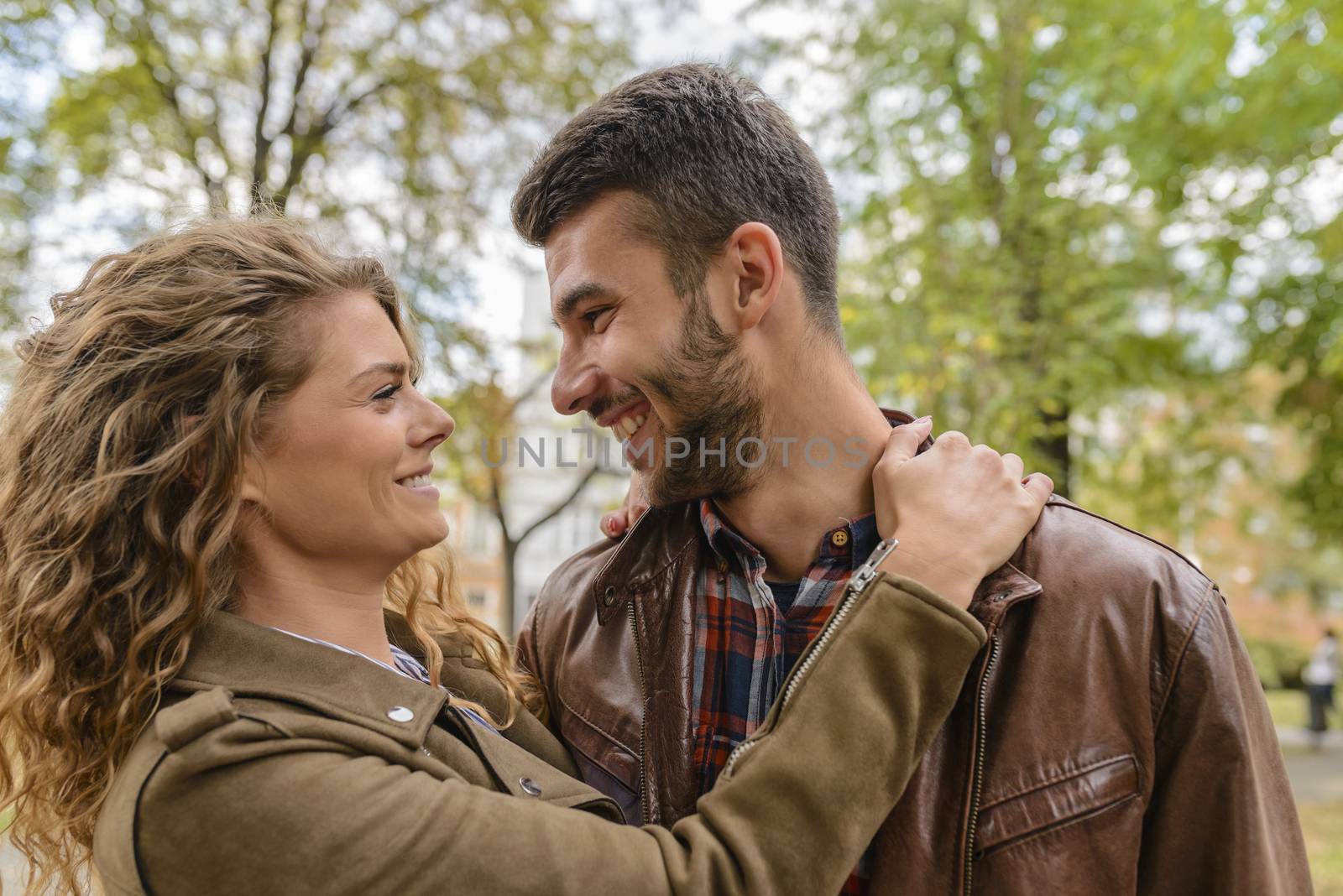 Young couple showing love in the city park by VeraAgency