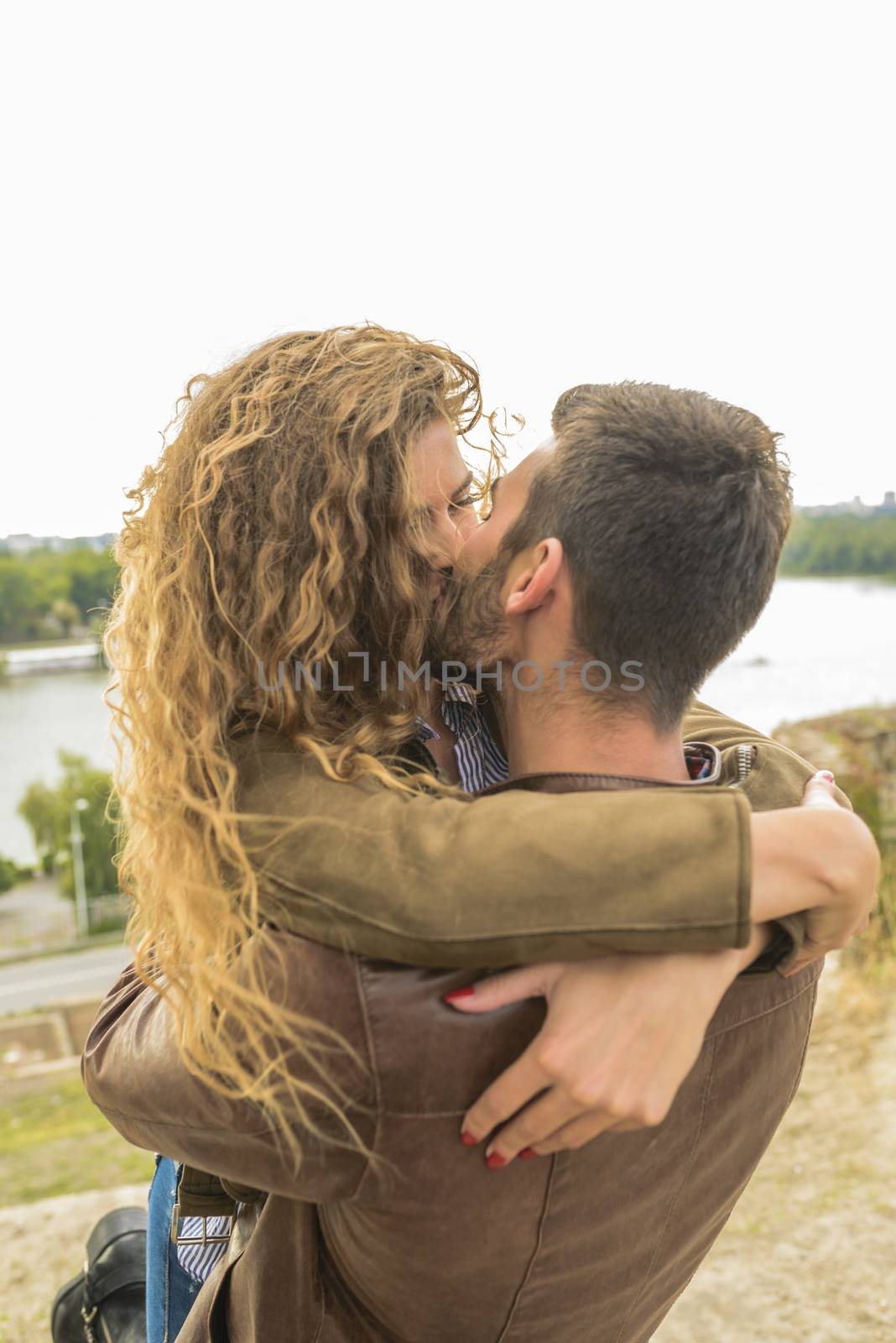 Attractive and modern lovers kissing in the nature