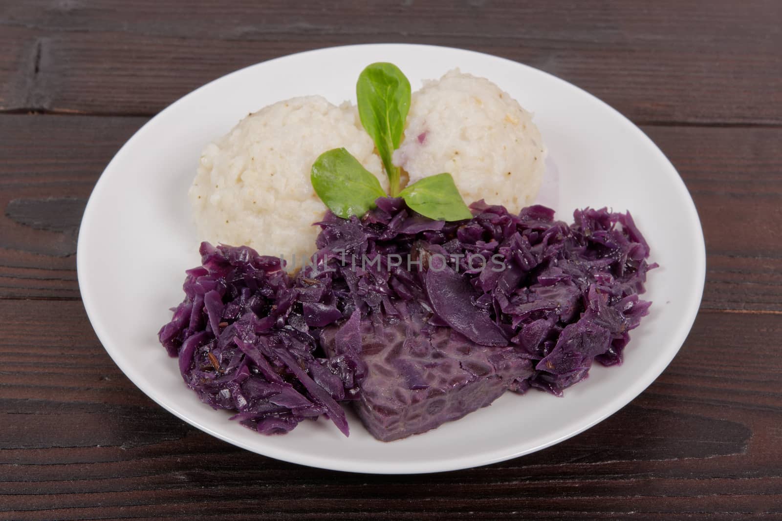 Tempeh with red cabbage and sorghum on a wooden table