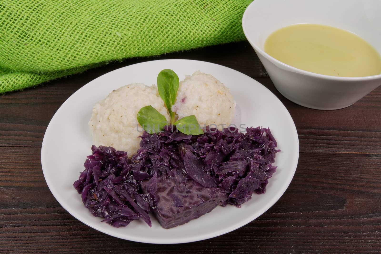 Tempeh with red cabbage and sorghum on a wooden table