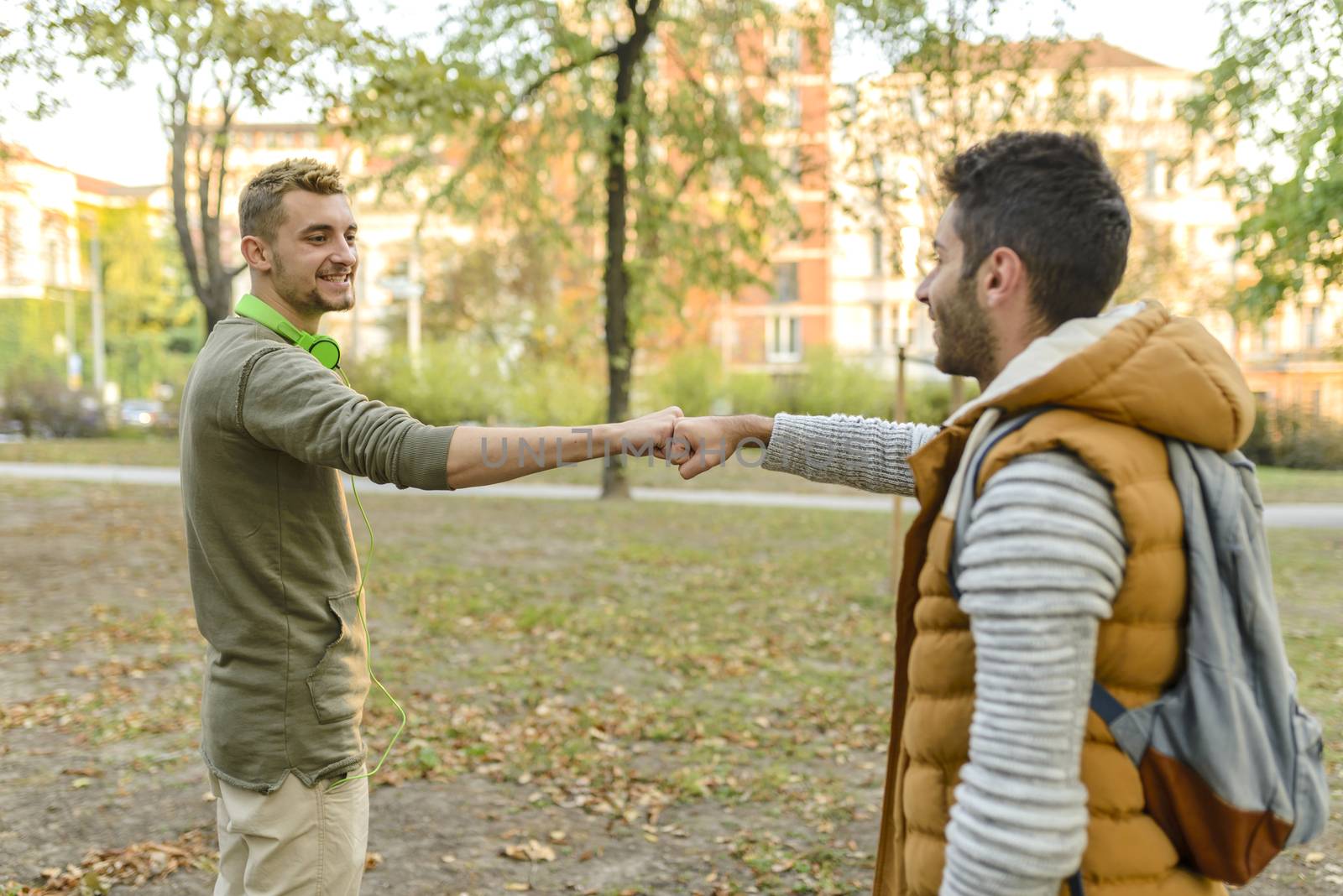 Two young man in the public park sending a greets to each other