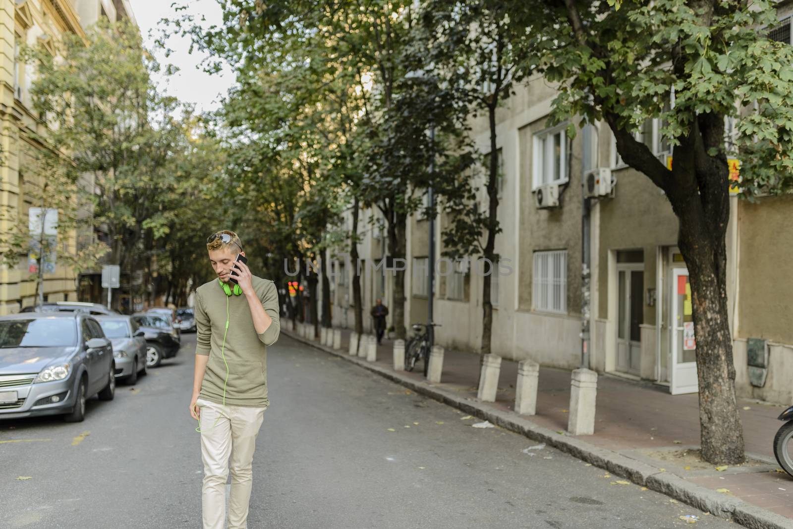 Young hipster with his smart phone in the city street