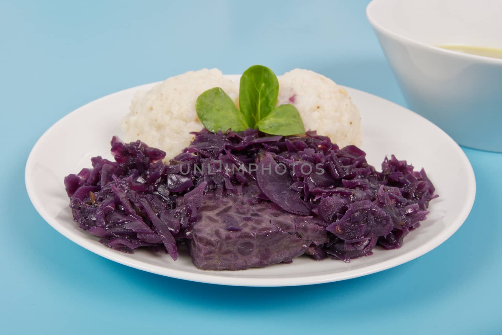Tempeh with red cabbage and sorghum on a blue background