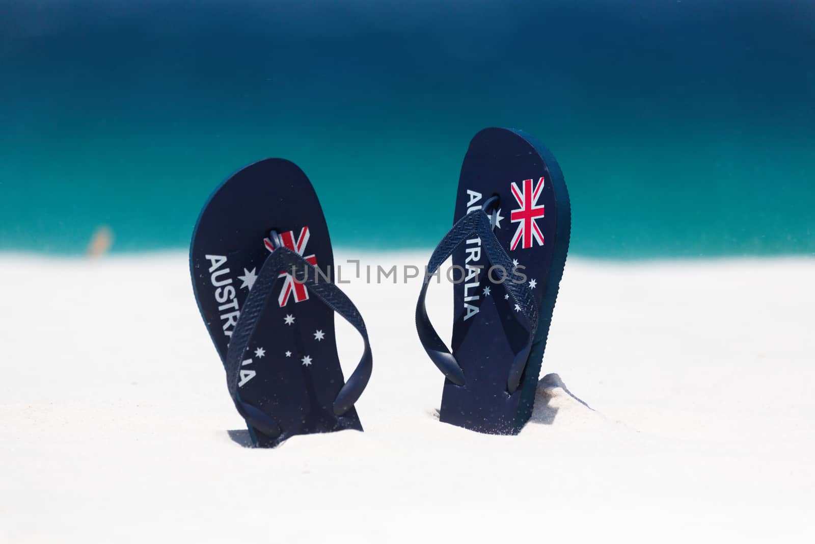 Australia Flag thongs in the sand by the beach in summer by lovleah