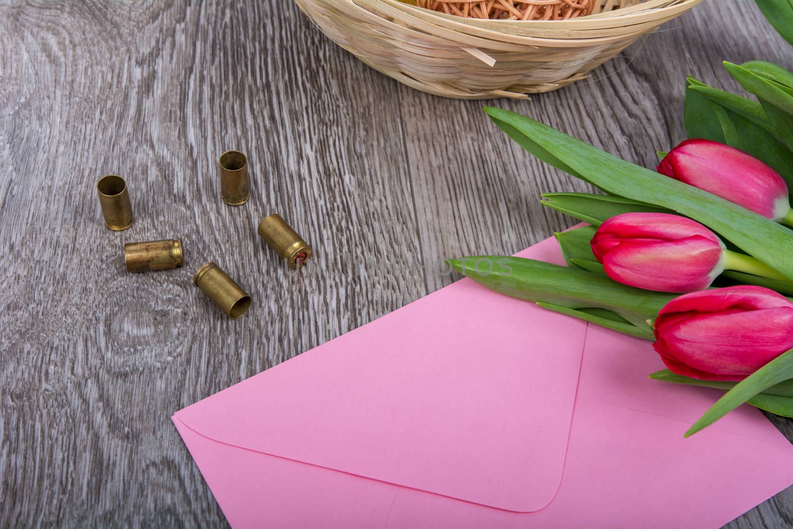 Pink envelope with tulips on a wooden table