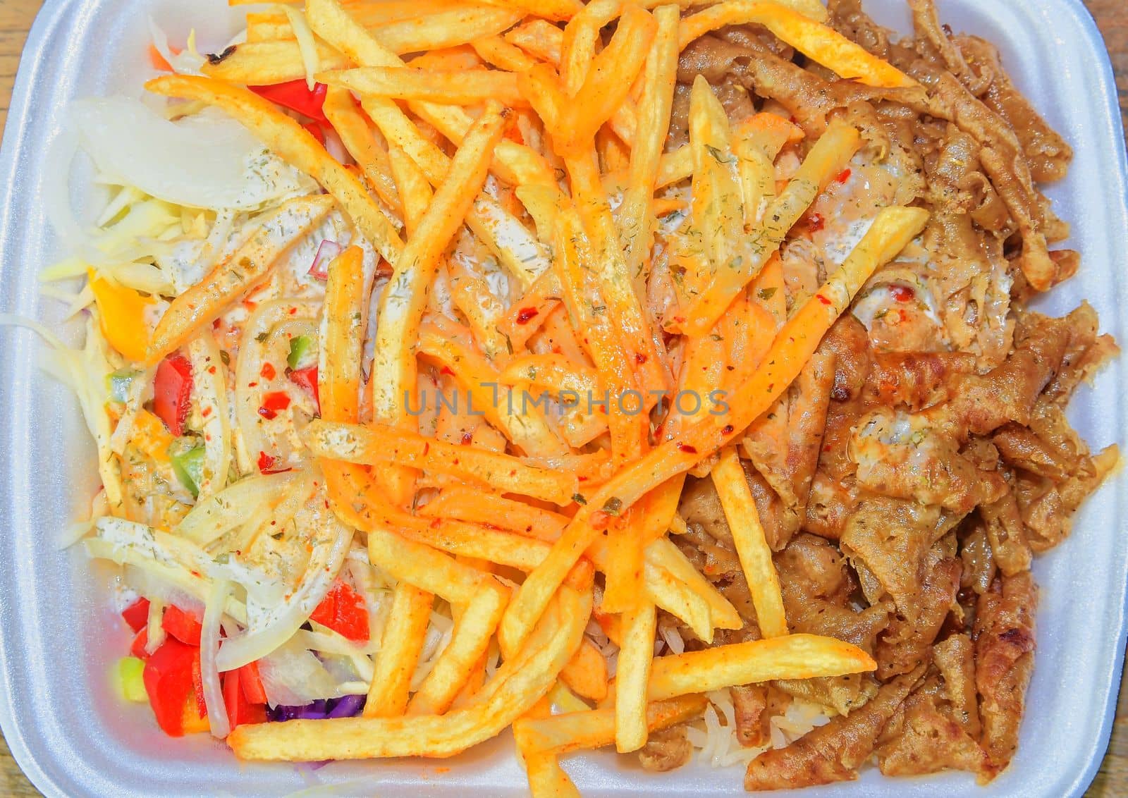 Fast food: kebabs, fries and fresh salad in the tray on the table. Unhealthy food concept. 