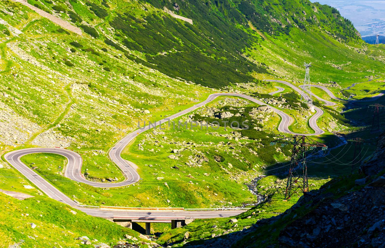 Legendary Transfagarasan road in Romanian mountains. winding serpentine among the grassy hills on a sunny morning