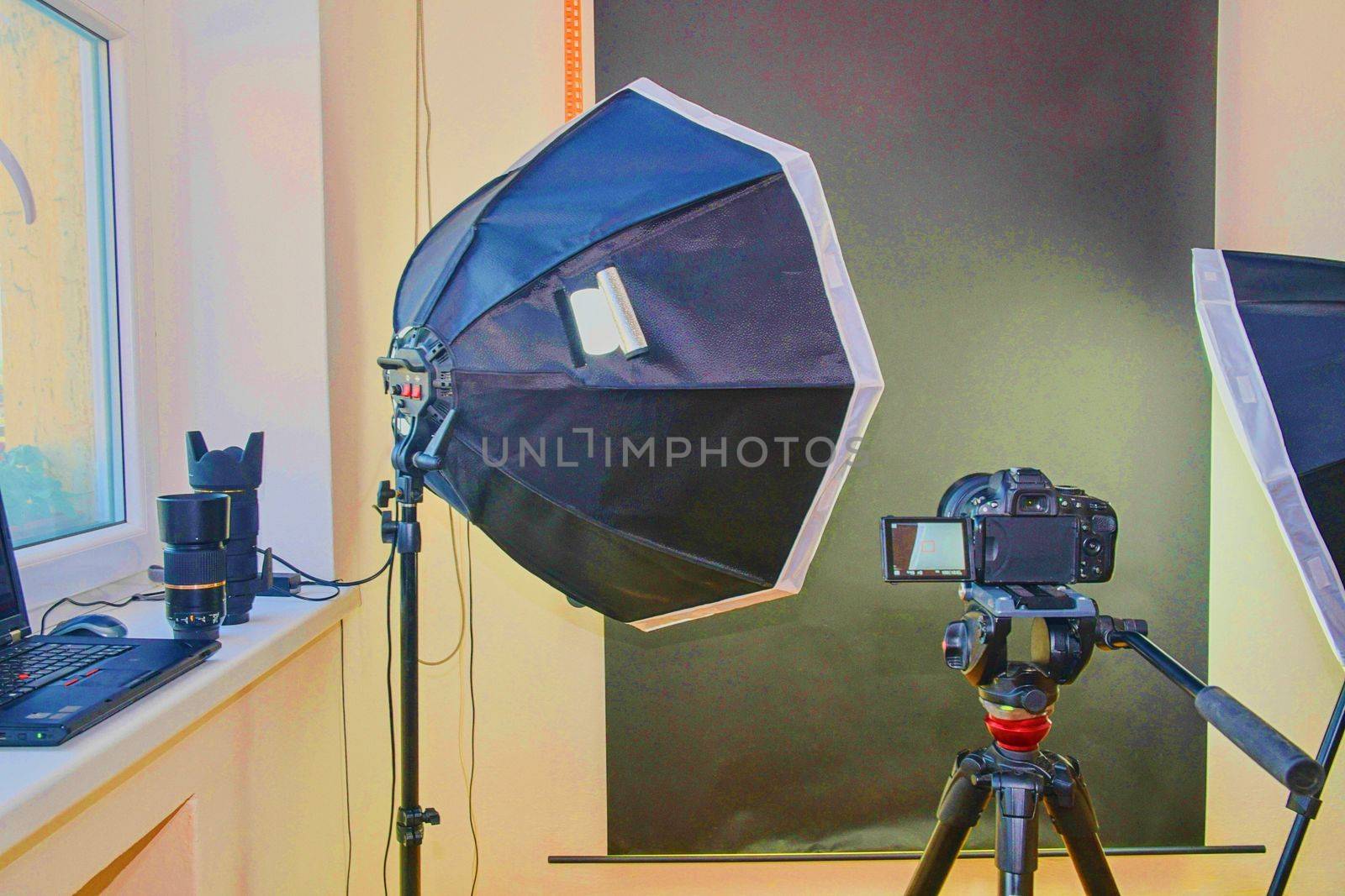 Empty photo studio with lighting equipment. Professional camera, lenses and filters for photographer by roman_nerud