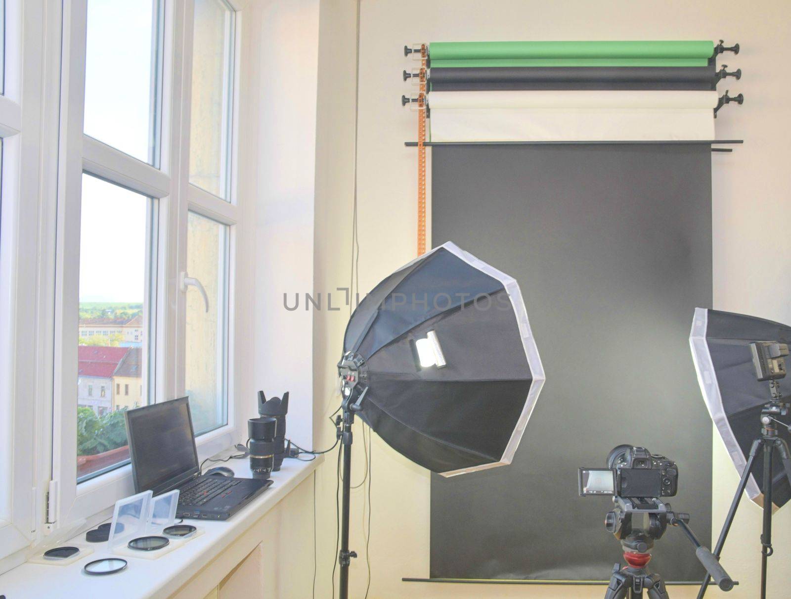 Empty photo studio with lighting equipment. Professional camera, lenses and filters for photographer.