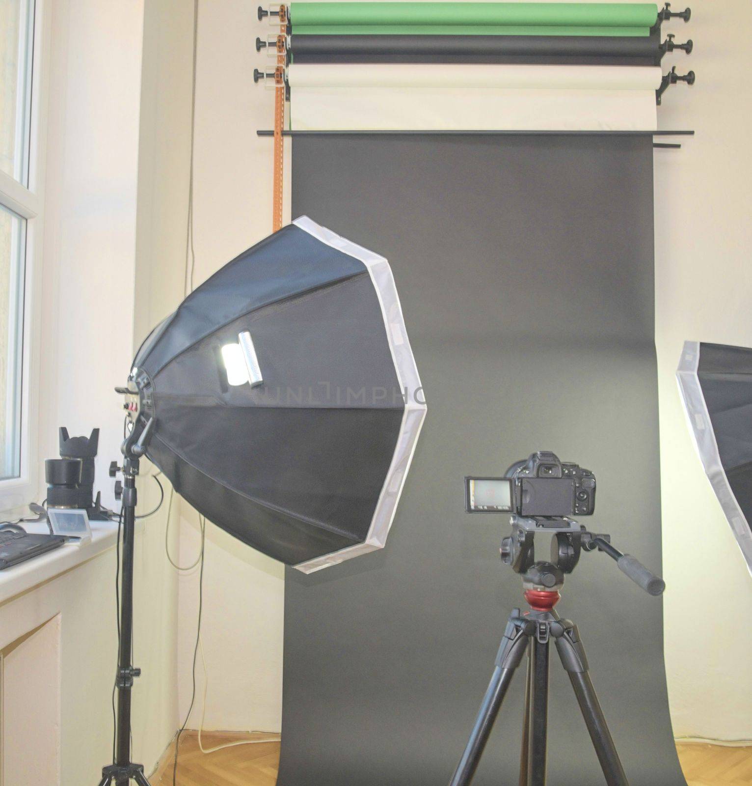 Empty photo studio with lighting equipment. Professional camera, lenses and filters for photographer.