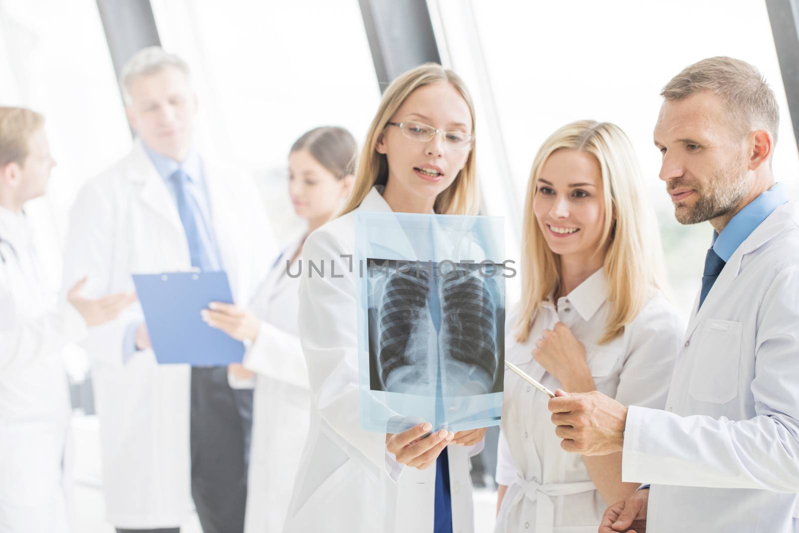 Group of young doctors look and discuss x-ray in a clinic or hospital