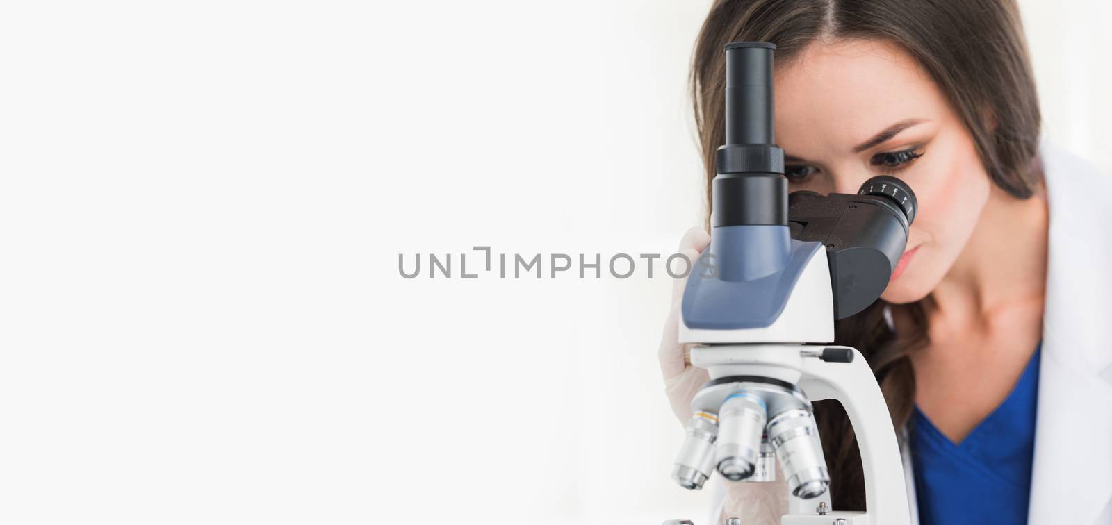 Female scientist working in a lab with microscope, isolated on white